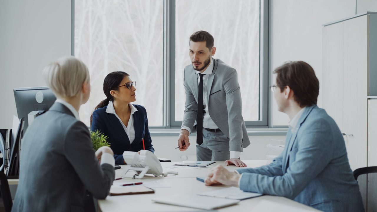 Two professionals in conversation during a meeting in a bright office